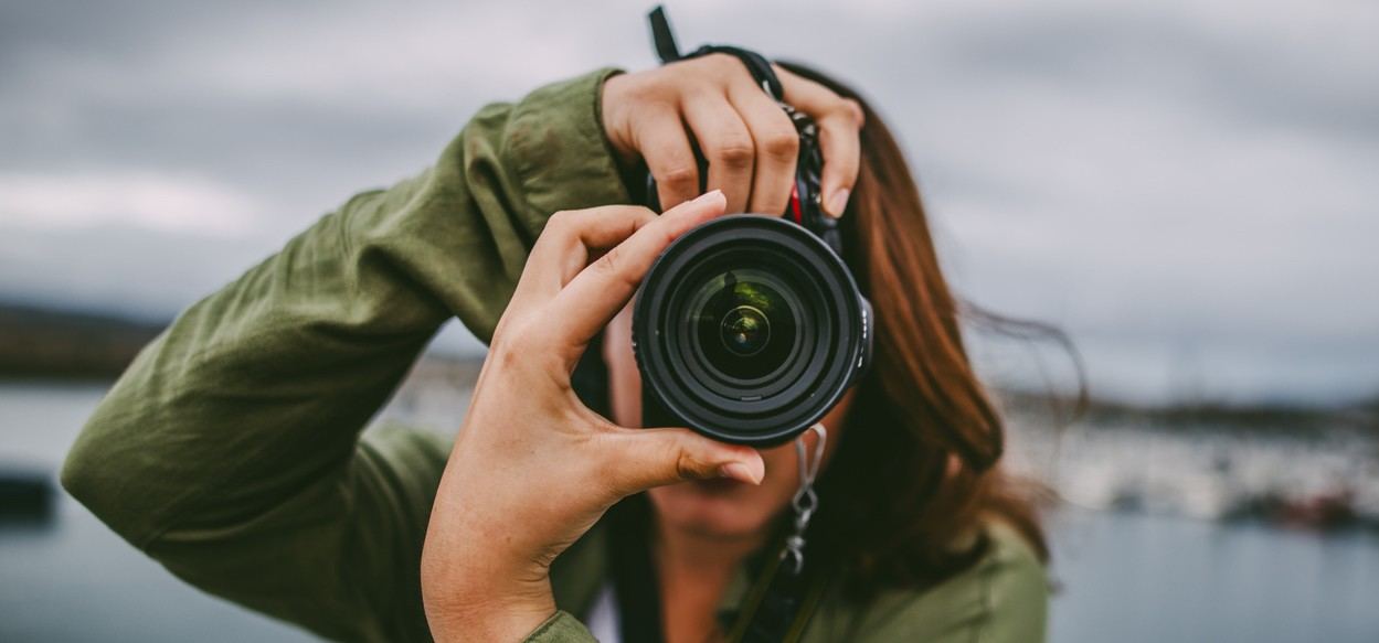 A young woman using a DSLR camera